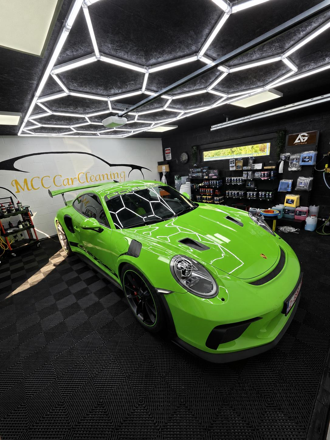 Glanzende groene Porsche in de MCC CarCleaning studio met hexagon verlichting